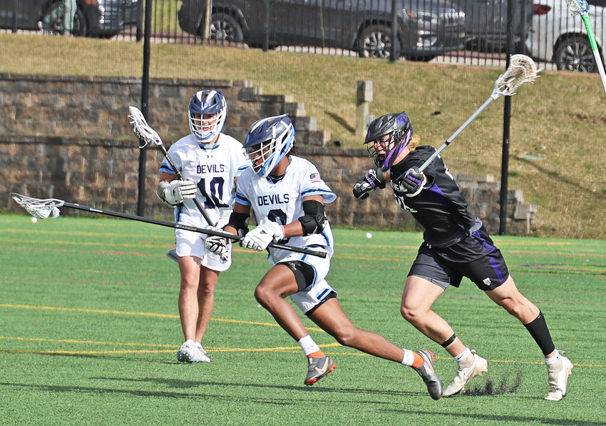 Aaron Clark (left), a freshman defenseman for the Blue Devils clears the ball out of the defensive end while pursued by Perkiomen's Rocky Grossman.  (Photo by Tom Utescher)