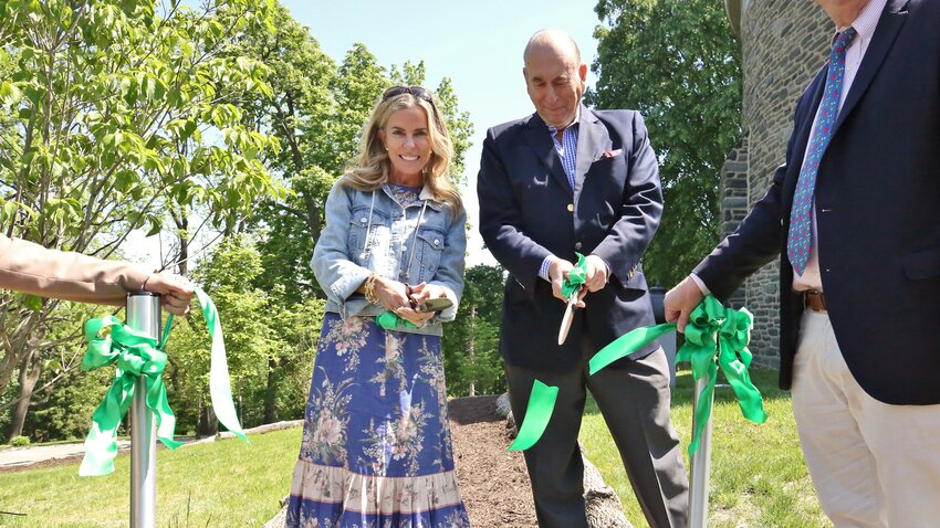 Megan Maguire Nicoletti, of the Maguire Foundation, and John Soroko, on behalf of the William B. Dietrich Foundation, help cut the opening ribbon at Woodmere's new outdoor art garden.