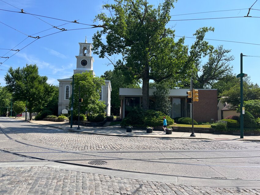 The building at 8623 Germantown Avenue, which used to house a Santander Bank branch and Palladio, a custom framing shop, sits next to a historic Baptist church.