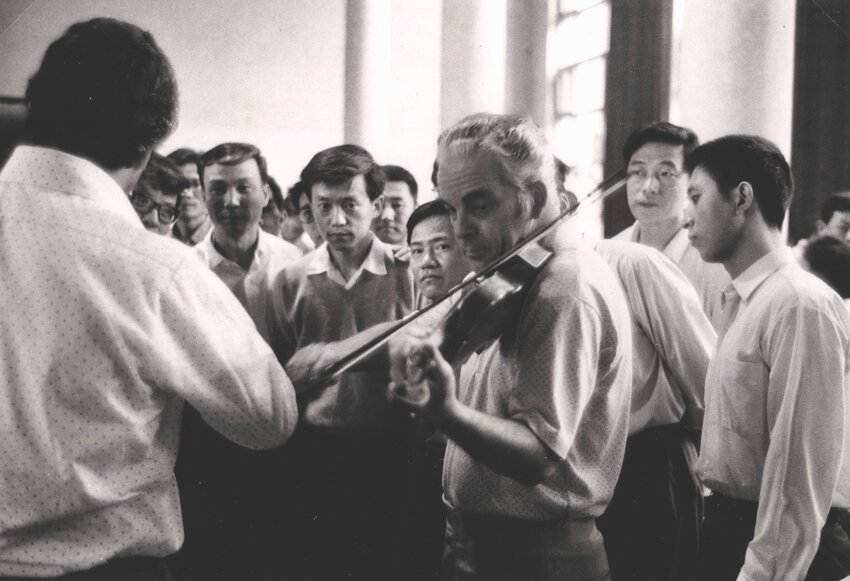 Chinese violinists with the Central Philharmonic gather around former Philadelphia Orchestra concertmaster Norman Carol during the orchestra's historic visit to China in 1993. Carol, who is now 95, retired in 2008.