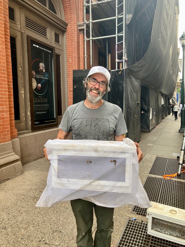 Eric Schoefer with some of the bees he captured on Locust Street near the Academy of Music.
