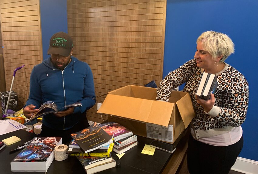 Gralin and Sara Zia Ebrahimi Hughes unpacking and organizing books that they plan on stocking in their store, Multiverse.