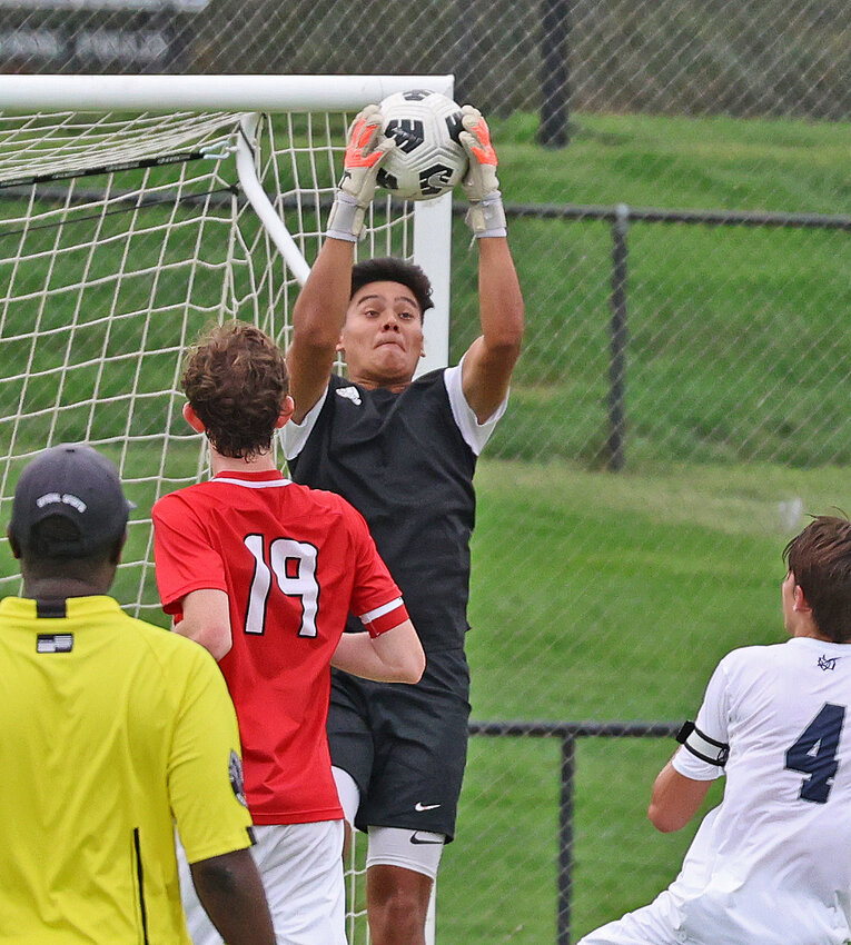 GA's senior goalie, Josh Bouchard, jumps up to grab the ball out of the air on a Malvern serve from the outside.