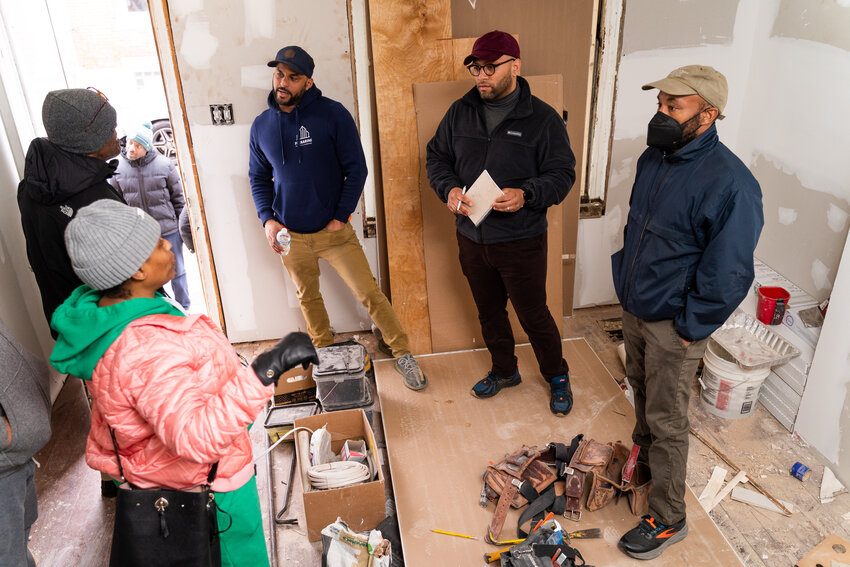 Jumpstart graduate Rhakeim Miller (picture in the center with a red cap and glasses) walks through a construction project as part of the coaching program.