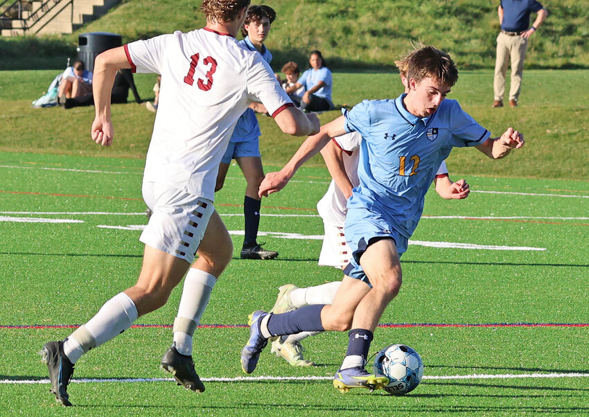 Blue Devils junior Michael Glennon splits a pair of Haverford defenders as he dribbles the ball through the midfield.