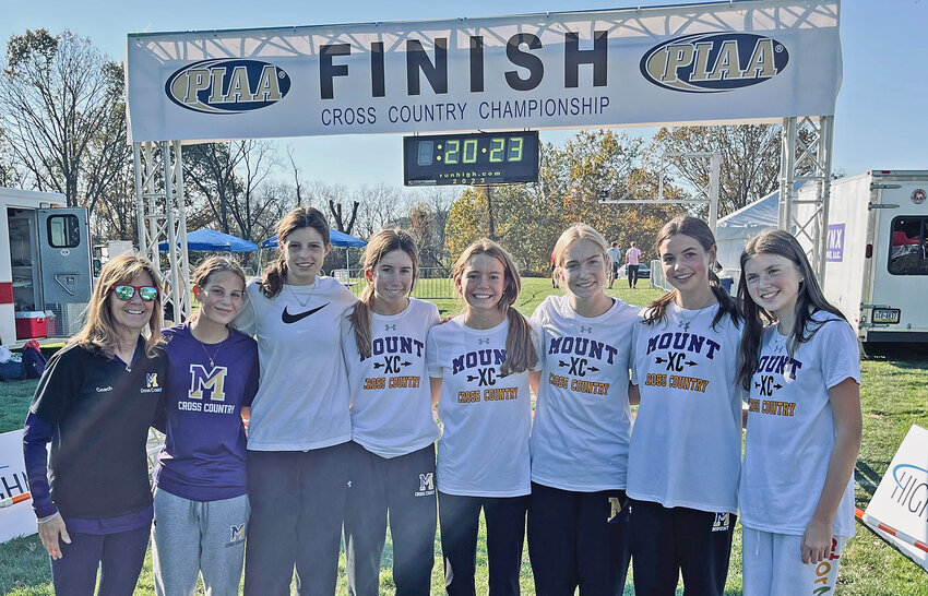 Mount St. Joseph Academy's varsity cross country runners pose with Coach Kitty McClernand at the finish line of the state championship meet in Hershey.
