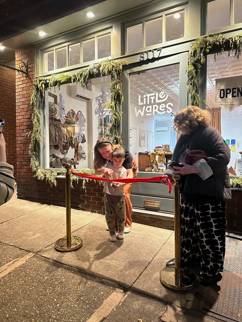 Kristin Leader Ramirez and her son Marco cut the ribbon at her new store, Little Wares, with Chestnut Hill Business District Retail Advocate Ann Nevel looking on.