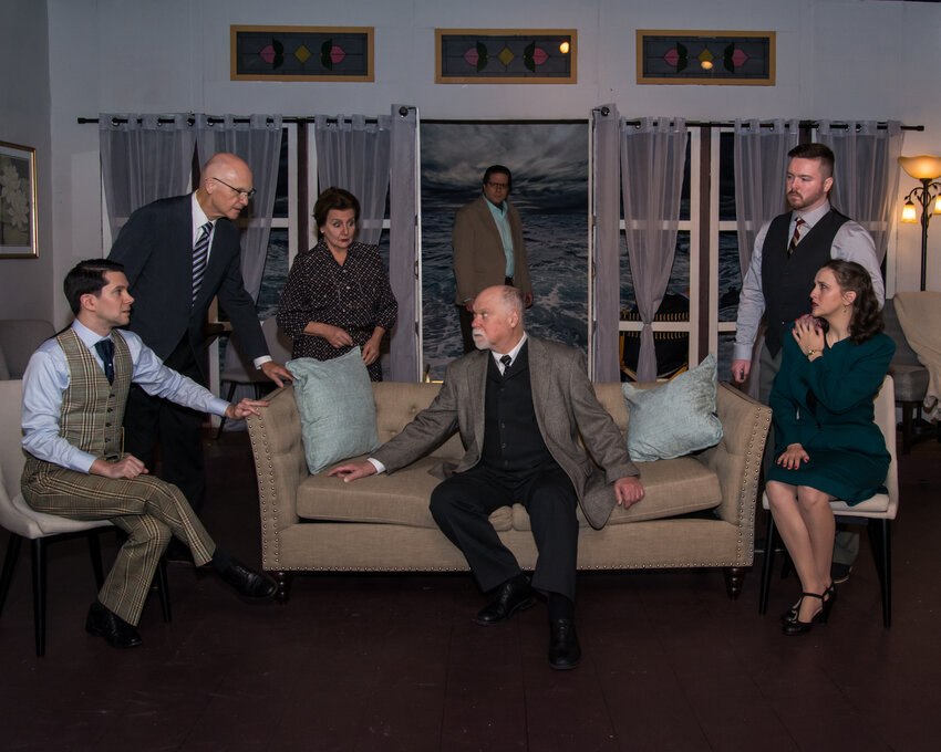 Seated on the couch, John Pinto (Justice Lawrence Wargrave) becalms a circle of frightened guests, (left to right), Brian Balduzzi (William Blore), Robert Overell (Rogers), Lorraine Barrett (Emily Brent), in the doorway, Michael Tarringer (Dr. Armstrong), Daniel McDevitt (Philip Lombard) and Rachel Dalton (Vera Claythorne).