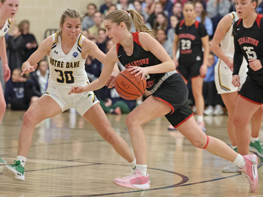 Jessica Kolecki of Germantown Academy dribbles past the top of the key while guarded by a fellow junior, Notre Dame's Sophie Hall.