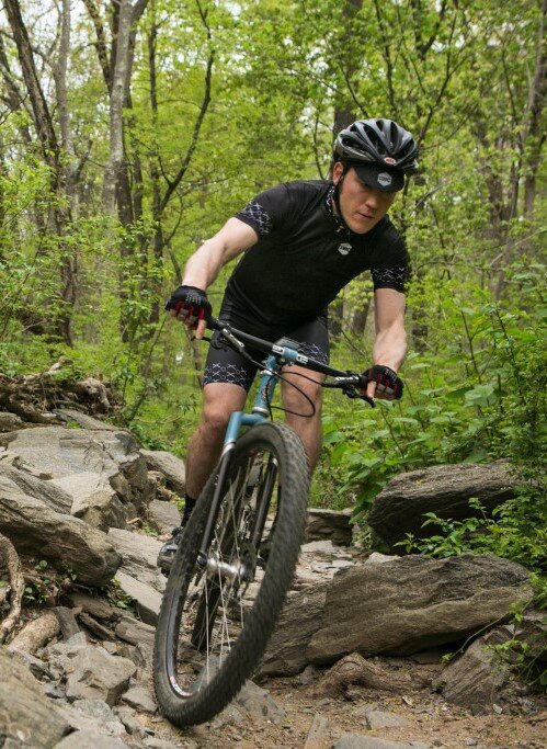 A mountain biker navigates a rock-strewn trail.