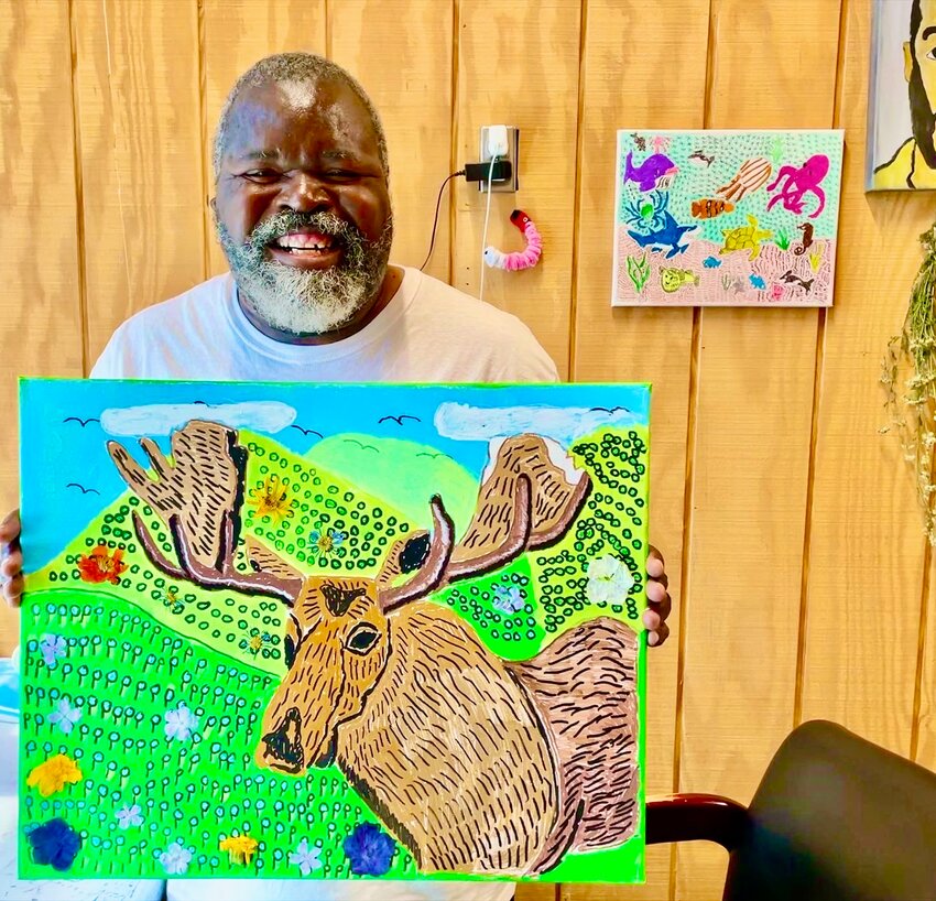 Dwayne Boone in his studio with his moose painting and collage.