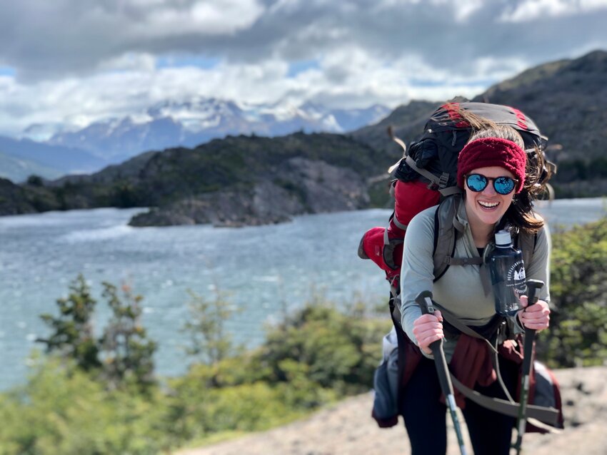 A passionate outdoorswoman and athlete, Hughes is seen here with an oversized backpack hiking in the Patagonia region of Chile with the &ldquo;Grey Glacier&rdquo; behind her.