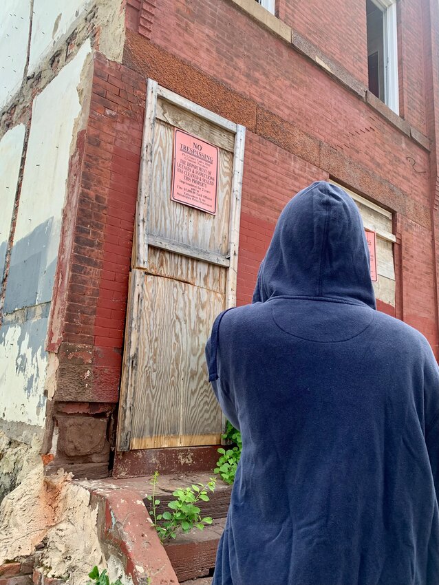 A young girl stands in front a vacant building in Mount Airy.