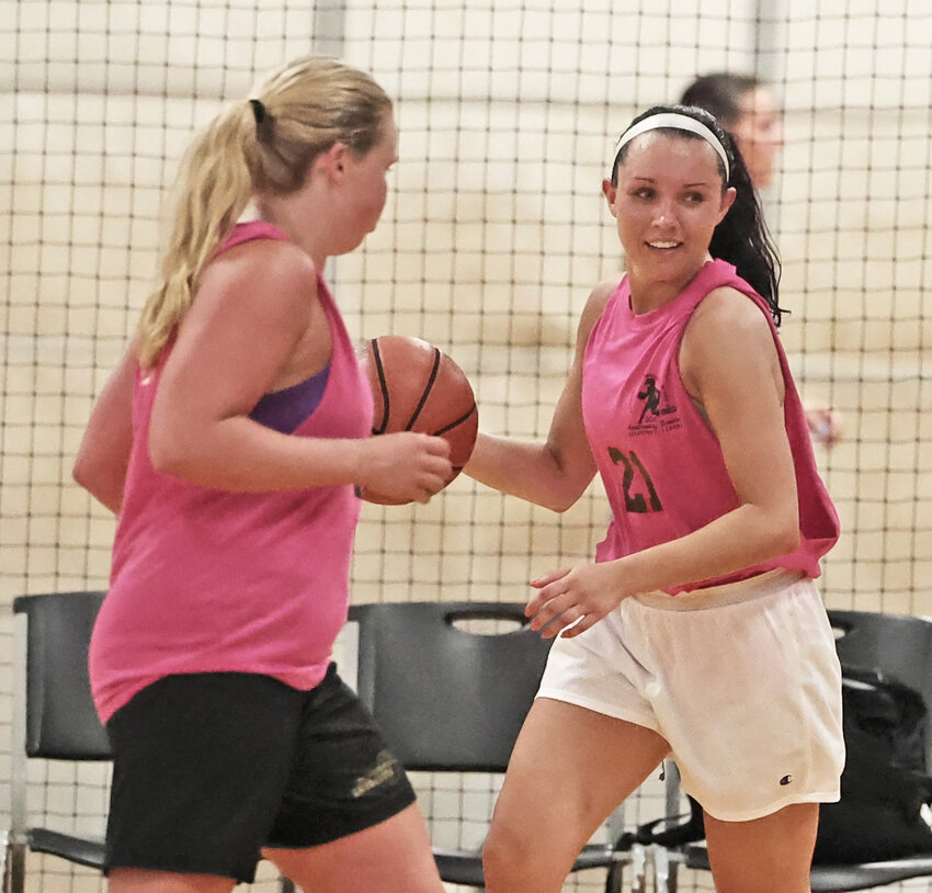 Former CHC point guard Cassie Spratt handles the ball for the Cyber Pink alumni team as another former Griffin, Lauren Crim (foreground) passes by.