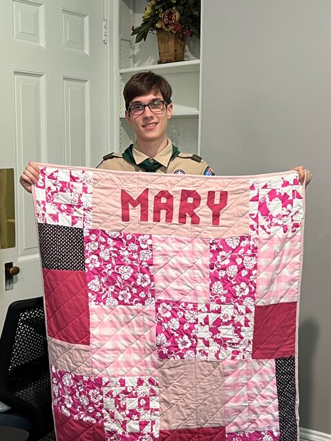Charles &ldquo;Chip&rdquo; Amuso, of Wyndmoor, shows one of the 10 quilts, each one 13 hours in the making, he and many other young people made for residents of Keystone House, a residential hospice care home in Wyndmoor.