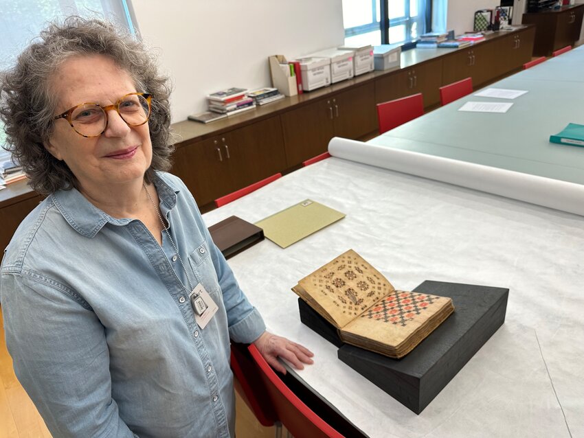 Philadelphia Museum of Art Senior Curator of Costume and Textiles Dilys Blum with the extremely rare 1723 Speck Manuscript, a detailed instruction guide to over 40 ancient weaving patterns like those on Oriental carpets, that has a connection to Chestnut Hill.