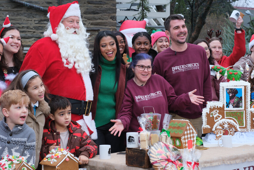 ABC News reporter Morgan Norwood poses alongside Diana Anello and Jake Boyd, of Bredenbeck's, during Good Morning America's broadcast from Chestnut Hill for the second time in two years on Tuesday.