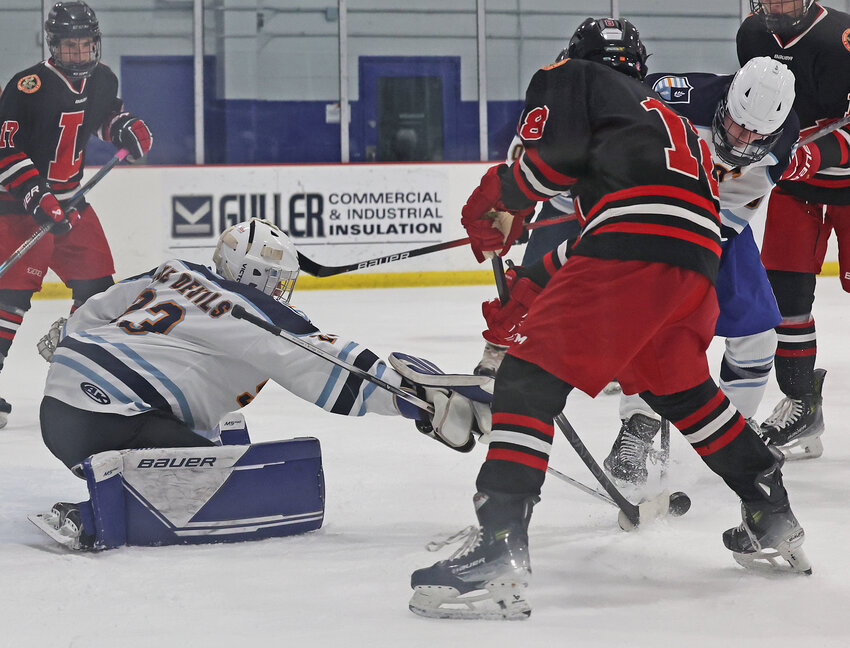 Blue Devils goalie Tristan Loder (left) thrusts his hockey stick toward the puck as Lawrenceville's Aaron Shen (center) and SCH's Sean Simmonds also battle for control.