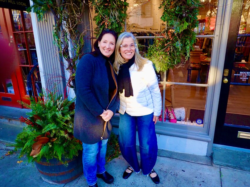 Dr. Jennifer Morello (left), a doctor-turned-award-winning floral designer, and Jennifer Spaeth stand in front of Laete, Spaeth's women's clothing store at 8436 Germantown Ave., where Morello designed the Christmas window displays.