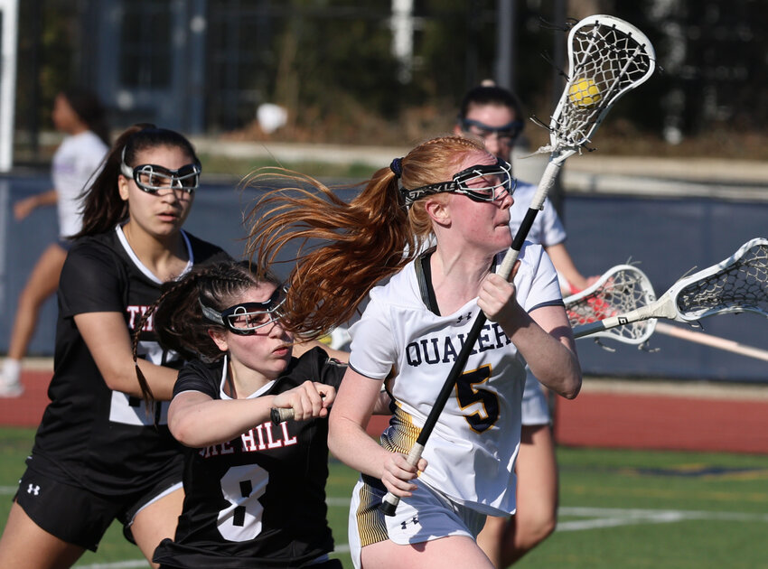 A check by Hill Academy's Beatrice Tamburro (# 8) fails to slow down Quakers junior Molly Dougherty as she charges toward the goal.