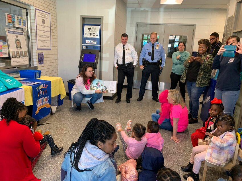 Rachel Blanchfeld, co-coordinator for the Philly Book Bank&rsquo;s Books from the Start program, reads to kids at an event at Philadelphia Police&rsquo;s 12th district headquarters.