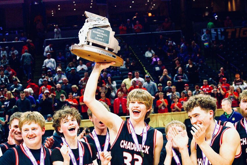 CHADWICK'S CLAYTON GARRISON is all smiles while holding the Cardinals' Class 1 state championship trophy Saturday.