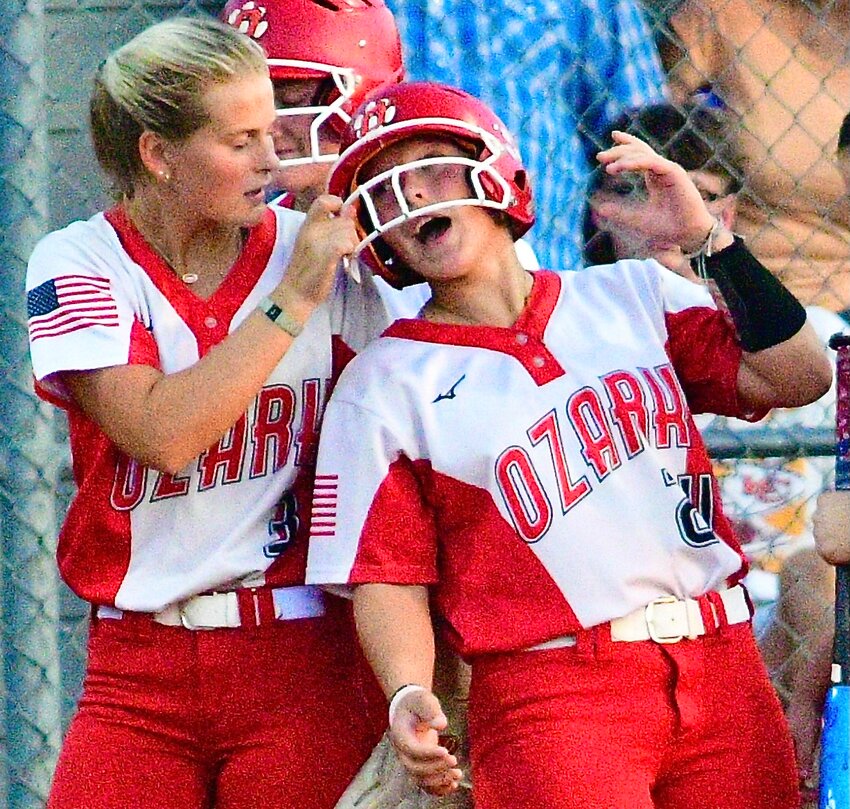 OZARK'S NATALIE MORGAN receives a tug on her face mask from teammate Kelsie Batey following a home run.