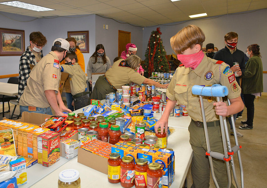 SCOUTS set-up an assembly line to fill boxes of groceries for veterans.