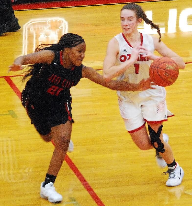 OZARK'S RILEY BOGGS maintains possession as a Jefferson City defender tries to tip the ball away from her Wednesday.