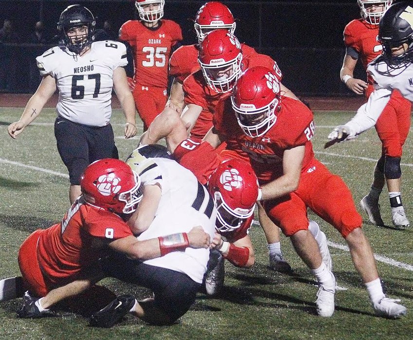 JACE EASLEY AND THOMAS RUSHING combine for a tackle for Ozark in the Tigers' 40-7 win over Neosho last week.