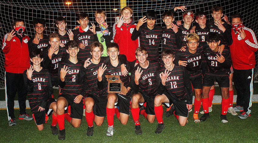 OZARK PLAYERS AND COACHES hold up three fingers after the Tigers' three-peated as District champs Wednesday.