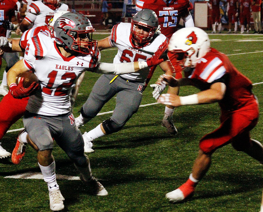 NATE NIXON tires to hold off a Webb City defender in Nixa's 28-0 loss to the Cardinals on Friday.