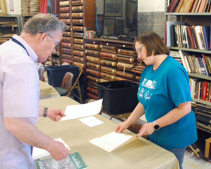 CHRISTIAN COUNTY WESTERN DISTRICT COMMISSIONER HOSEA BILYEU (left) submits an item for the Christian County 2021 time capsule, a copy of a publication called &ldquo;Ozarks Watch,&rdquo; to Christian County Museum and Historical Society President Shannon Mawhiney.RANCE BURGER/Headliner News