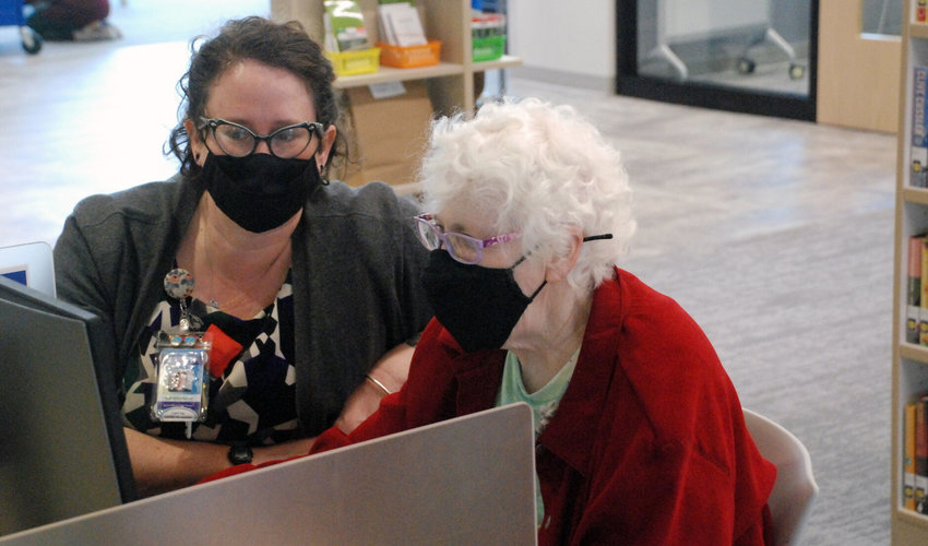 FROM LEFT, SPARTA LIBRARY BRANCH MANAGER WHIT GILLENWATERS ASSISTS FORMER CHRISTIAN COUNTY LIBRARY DIRECTOR MABEL PHILLIPS on the first day that the Sparta library branch was open to the public.