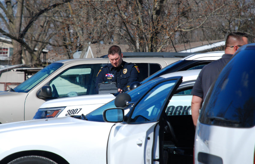 Ozark Police Chief Justin Arnold works at the scene of an investigation on South Street in March 2020.