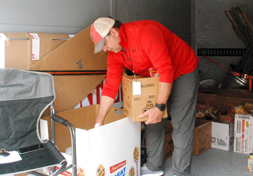 OZARK BOARD OF EDUCATION MEMBER SHANE NELSON volunteers at a food distribution site at West Elementary on behalf of Care to Learn on May 1, 2020.