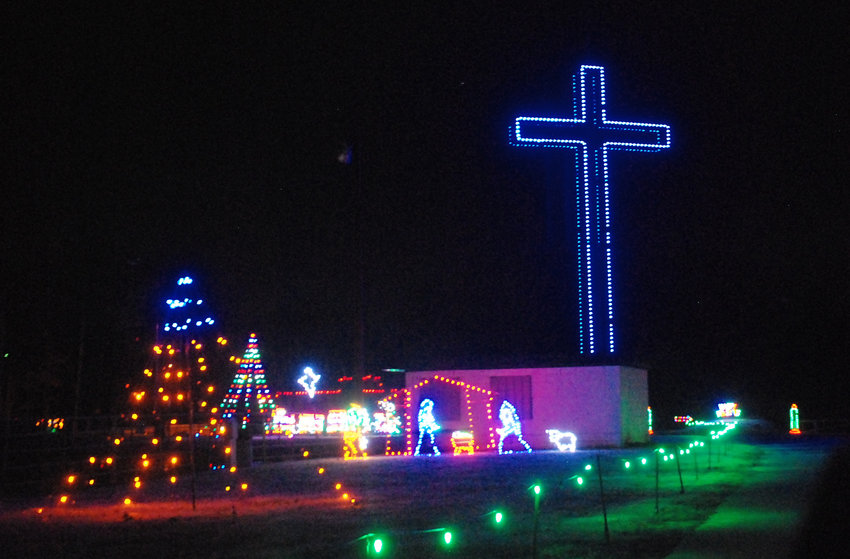 A LARGE BLUE LIGHTED CROSS stands among the holiday light displays at Finley River Park in Ozark.