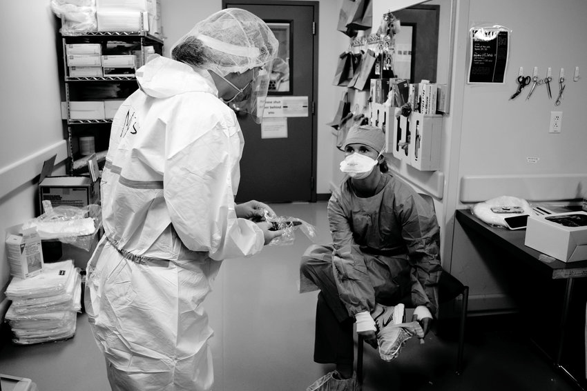 HOSPITAL WORKERS at CoxHealth don personal protective equipment (PPE) before entering a COVID unit to treat patients.