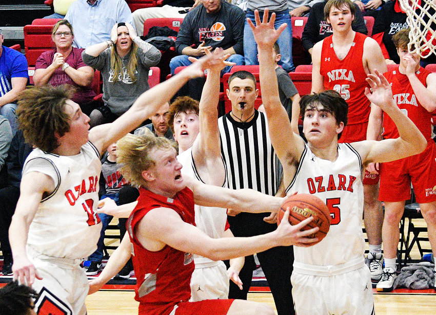 NIXA&rsquo;S JARET NELSON drives to the hoop in between Ozark&rsquo;s Colton Ballard, Devyn Wright and Greydon Miller on Tuesday.