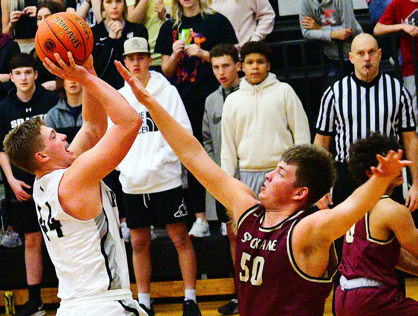 SPARTA&rsquo;S DEXTER LOVELAND shoots over Spokane&rsquo;s JD Tate in the teams&rsquo; Class 3 District 11 contest Monday.