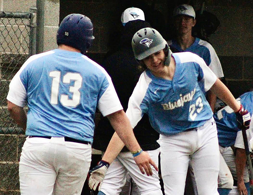 CLEVER'S SETH MCGAUGHEY receives congrats from Brennan West after scoring a run Monday versus Spokane.