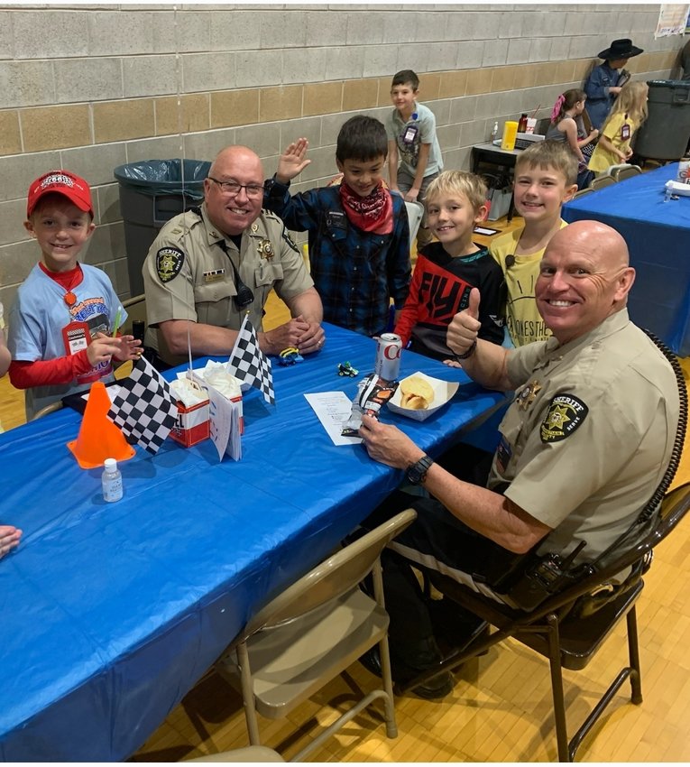 School Resource Officers Capt. Mark Deeds, left, and Officer Steve Hoerning enjoy a lunch served by Ozark East Elementary&rsquo;s second graders (from left): Emerson, Xavier, Owen and Easton on April 26.