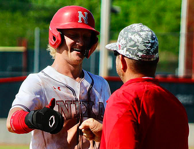 NIXA&rsquo;S JARET NELSON receives congrats from third-base coach Troy Nimmo.