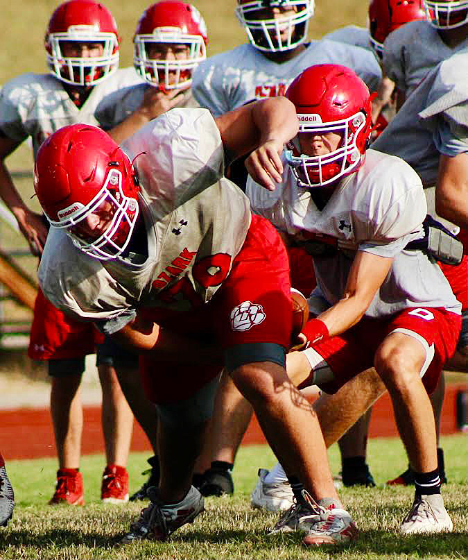 OZARK&rsquo;S PEYTON GREER hikes the ball to quarterback Brady Dodd during summer camp.