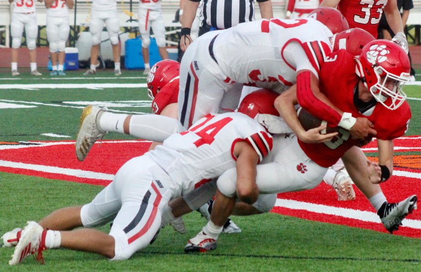 OZARK'S BRADY DODD is tackled by a pair of Carl Junction defenders Friday.