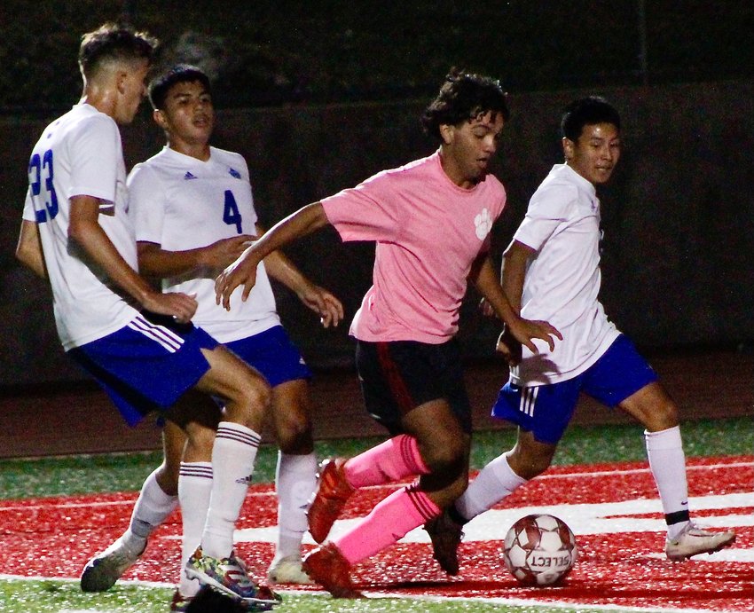 OZARK'S ADRIAN ORTEGA controls the ball in front of three Carthage defenders Tuesday.