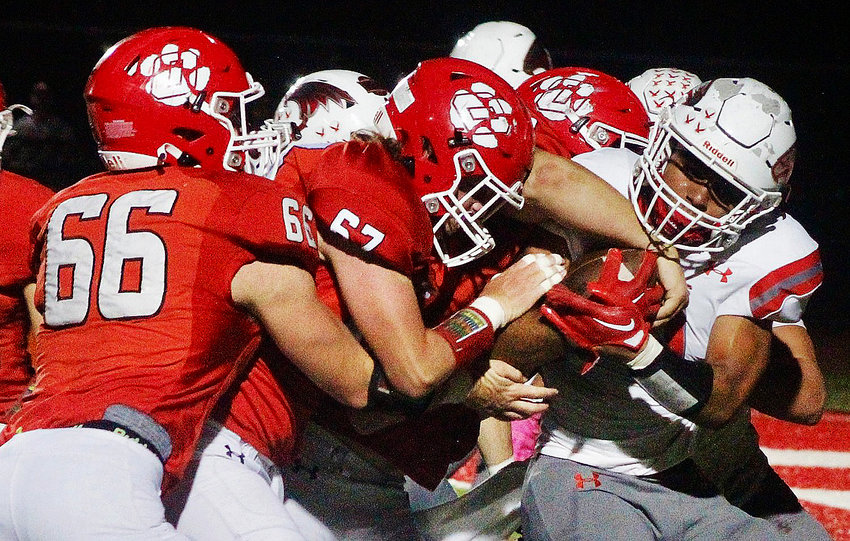 NIXA&quot;S SPENCER WARD holds onto the football after recovering an Ozark fumble during the Backyard Brawl on Friday.