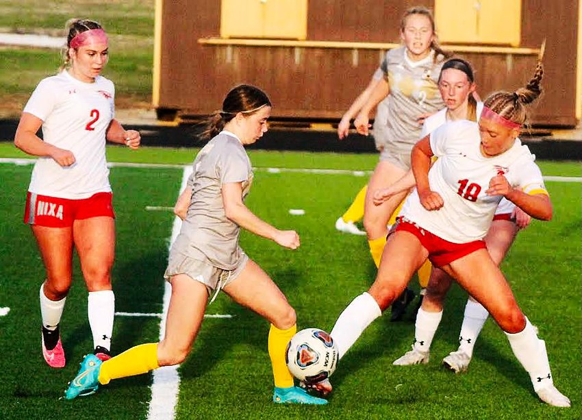 NIXA'S BAILEY SNYDER battles for possession of the ball at Kickapoo on Friday.