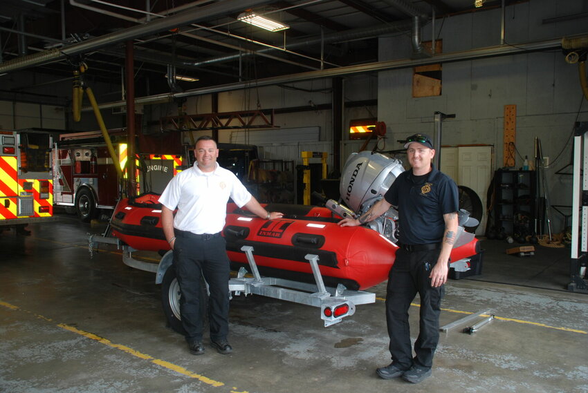 Assistant Fire Chief Aaron Heaton (left) and Captain Kyle Heminger with the new boat for Ozark Fire's Swift Water Rescue Team.