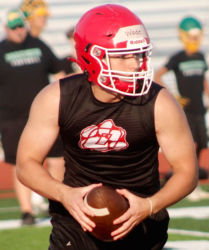 OZARK'S FISHER WADE scrambles out of the pocket prior to making a pass in 7-on-7 action.